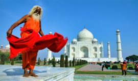En man poserar framför Taj Mahal på en resa till Indien